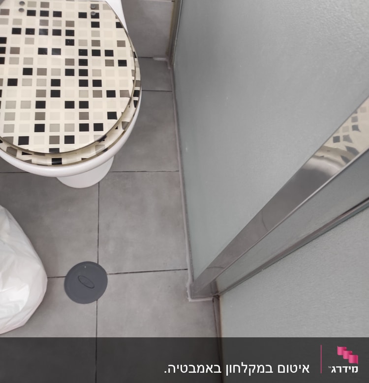 אסלה עם מושב מעוצב, רצפת אריחים, ניקוז עגול